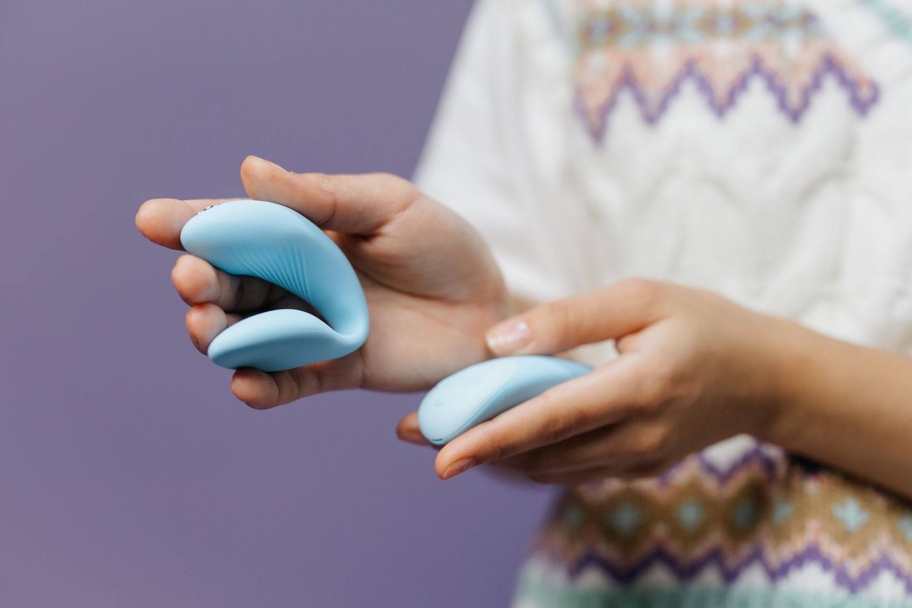 Close-up of hands holding a sleek vibrator, representing rediscovering solo pleasure.