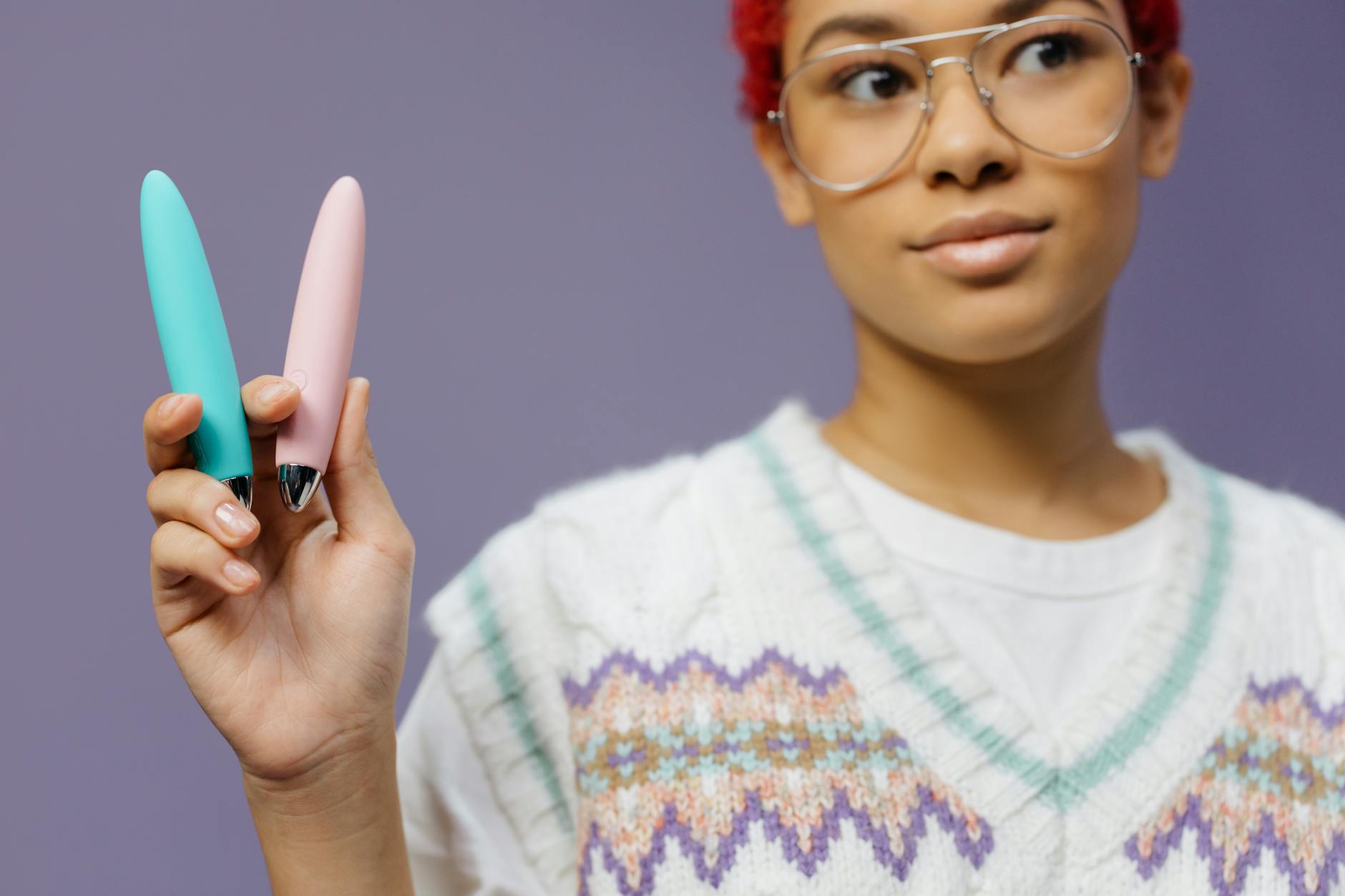 Frau mit bunten Vibratoren auf violettem Hintergrund, die verschiedene Stimulationsstile zeigt