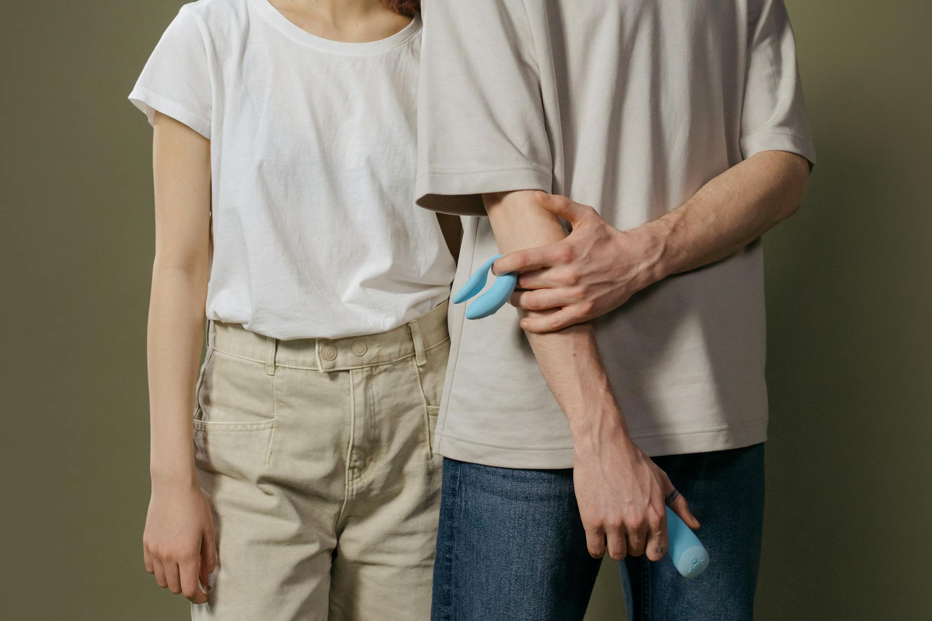 A young couple standing together indoors, exploring intimacy and pleasure together