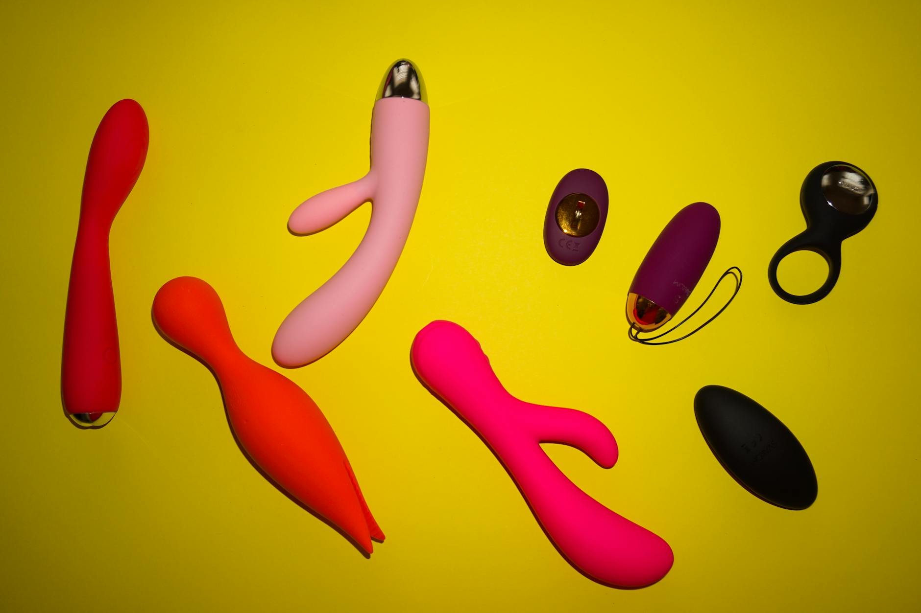 Vibrant collection of colorful lemon vibrators and adult toys displayed on a bright yellow surface